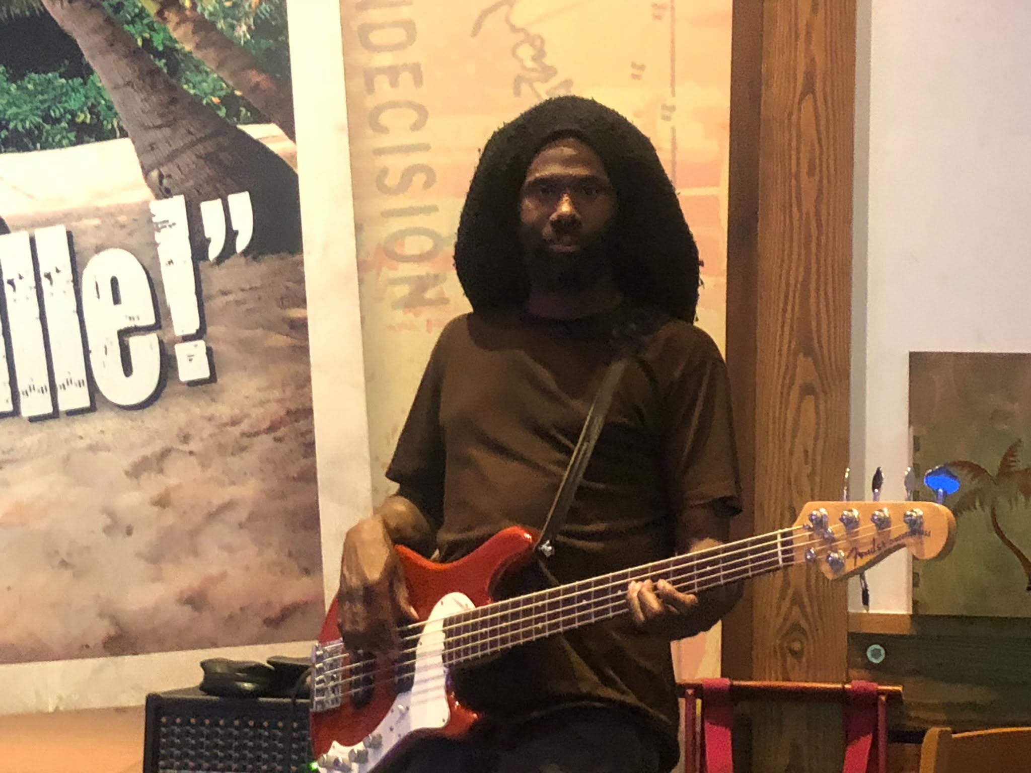 One Love bassist playing a red bass guitar