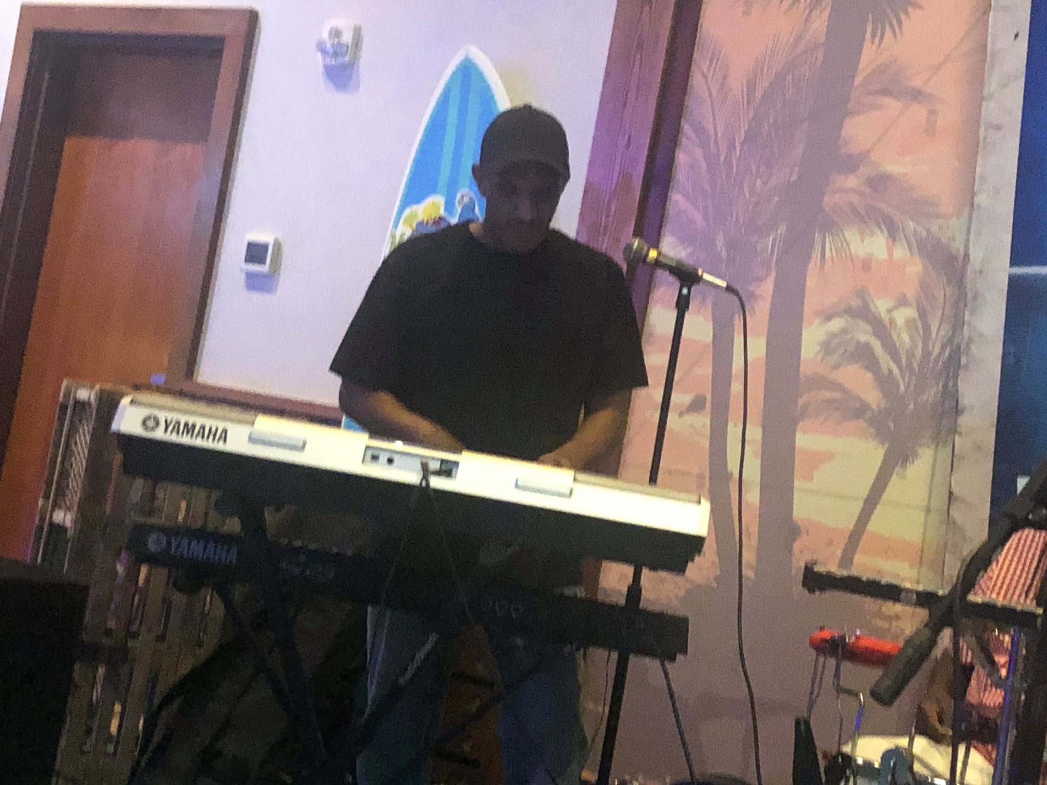 One Love keyboardist singing at a Yamaha keyboard